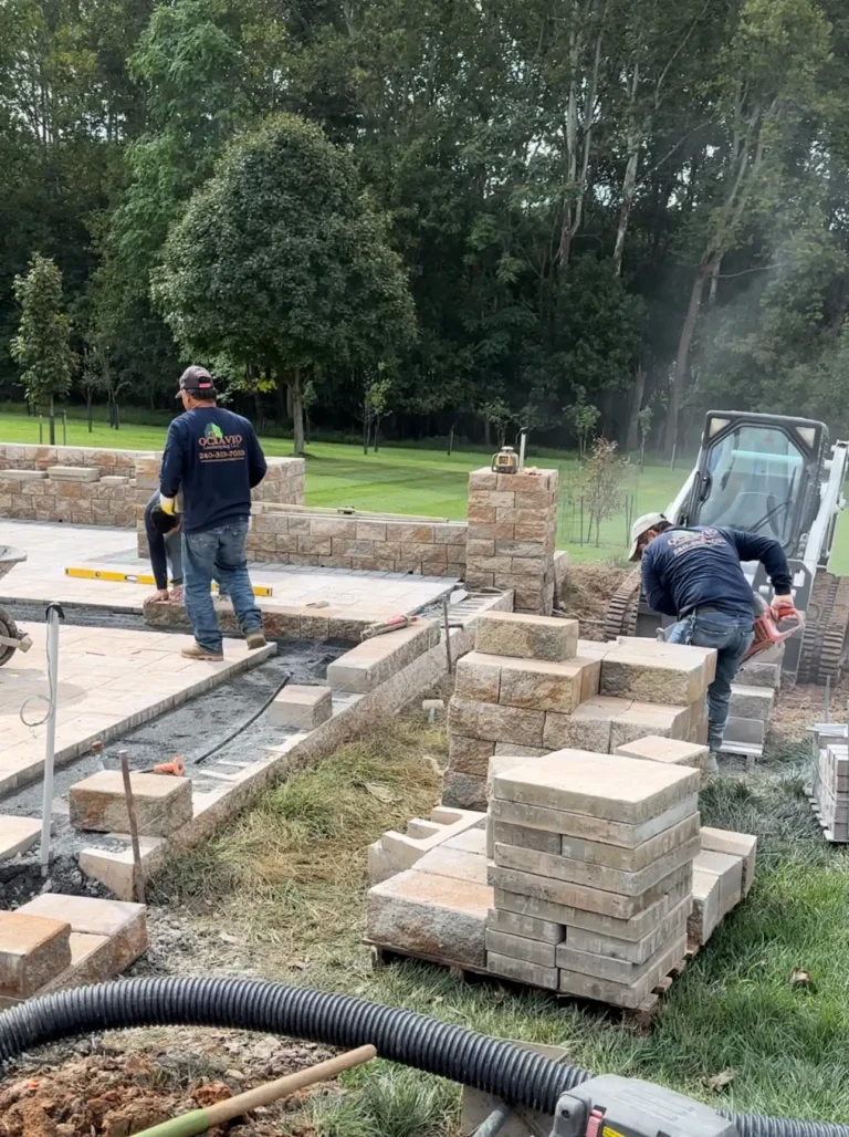 Hardscape team installing stone blocks for patio walls — Landscaping in Silver Spring, MD